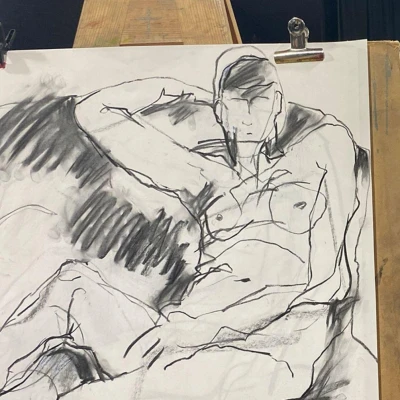 Charcoal drawing of a reclining nude figure on a surface, one arm behind the head; bold lines with heavy shading across the torso.